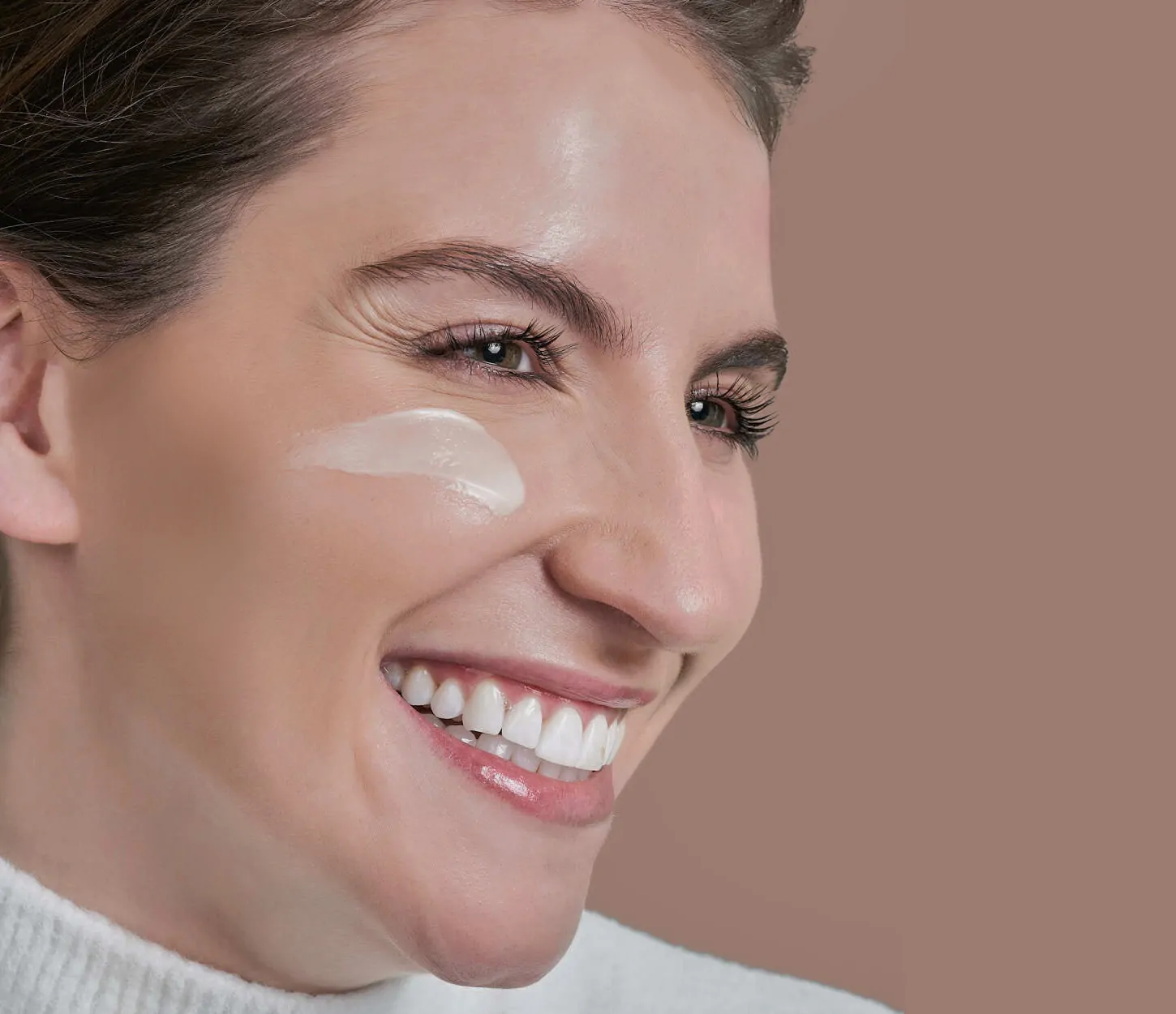 Woman with cream on her cheek